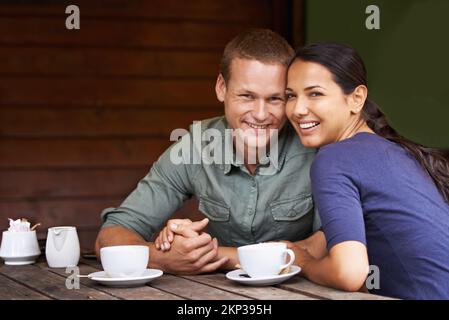 Bonding over a cuppa. a young multi-racial couple enjoying a cup of coffee at a restaurant. Stock Photo