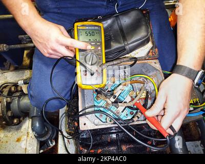 checking insulation of windings of a grounded motor with megger tester,damaged motor,megger,megger tester,motor winding damge,electrical motor checki Stock Photo