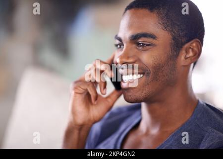 Checking up on that special someone. a handsome young man using his cellphone while chilling at home. Stock Photo