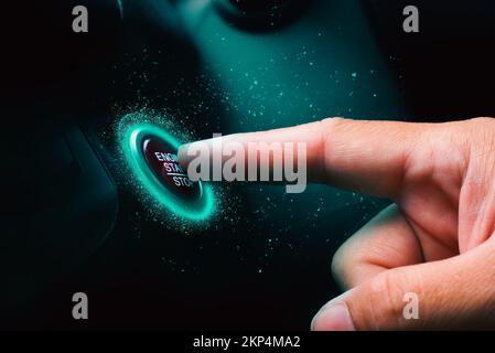 The driver palm as it presses the electric car engine start stop button with a blue light illuminated in the darkness Stock Photo