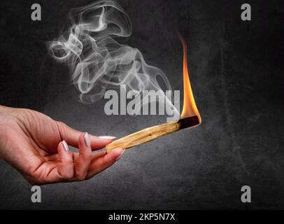 palo santo burning in front of dark background Stock Photo