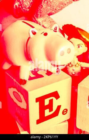 Toy piggy bank in retro tones of red and beige on the blocks of early development. Piggybank poster Stock Photo