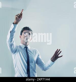 The future is now - Touchscreen technology. a young businessman using an unseen digital interface. Stock Photo