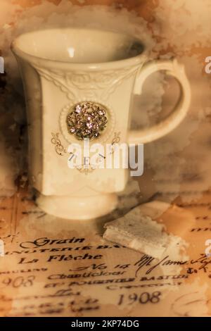 Fine artwork of an ornate teacup on typography table cloth. Tea cups and vintage stains Stock Photo