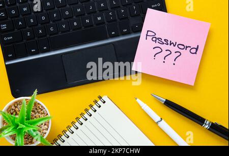 Pink sticky note with password ??? Written on a laptop keyboard. Stock Photo