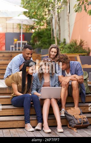 The queen bee showing us how to study. A shot of university students working together outdoors. Stock Photo