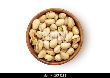 Pistachio nuts in wooden bowl on white background Stock Photo