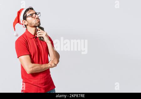 Young man in christmas clothes thoughtful with cell phone isolated, Handsome man in christmas clothes thoughtful holding cell phone. Thoughtful man wi Stock Photo