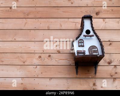 Birdhouse or roost box on the wooden wall of a building, selective focus. Care for animals, copy space Stock Photo