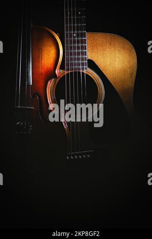 A violin and acoustic guitar on a black background Stock Photo