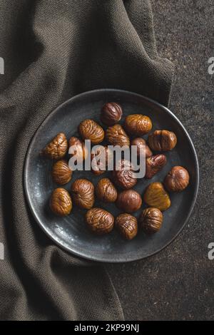 Peeled chestnuts. Sweet roasted chestnuts on the plate. Top view. Stock Photo