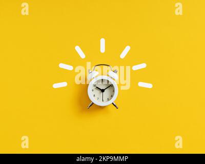 White retro alarm clock ringing on yellow background. Stock Photo