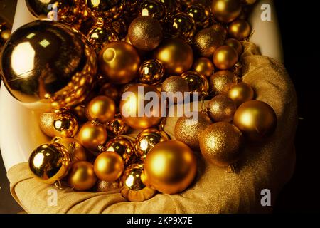 Bathtub full of golden balls. Vintage bright bathroom decorated with festive golden balls. New Year, Christmas bathroom interior. Stock Photo