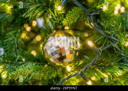 gold ball christmas decoration on a christmas tree with lights Stock Photo