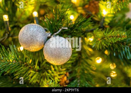 close-up of silver glitter balls christmas decoration on a christmas tree with lights Stock Photo
