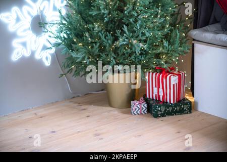 Christmas presents under the Christmas tree. New Year's and Christmas. Wrapped Gift. Beautiful packaging. Ribbon and bow on the packaging. Stock Photo