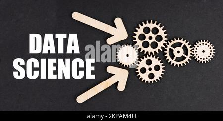 Industrial concept. On the black surface, arrows, gears and an inscription - DATA SCIENCE Stock Photo