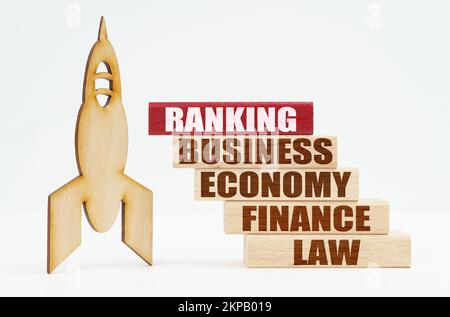 Business and finance concept. On the white surface there is a wooden rocket and planks, on the red plaque the inscription - RANKING Stock Photo