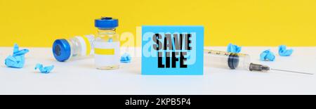 Medicine and health concept. On the table is a syringe, injections and a blue sign with the inscription - save Life Stock Photo