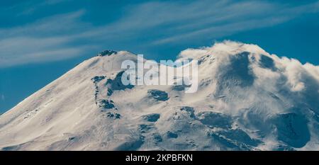 Big mountain Elbrus. Snow covered Greater Caucasus mountains. The two peaks of Mount Elbrus . Europe's highest peak. Journey to Kabardino-Balkaria. Russia. The trail to the top of the mountain.  Stock Photo