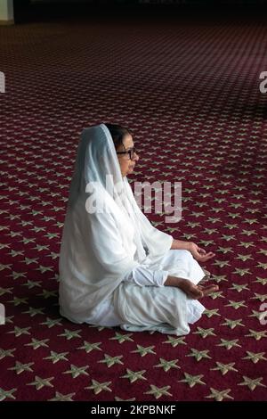 A Sikh woman prays and meditates in a temple in Richmond Hill, Queens, New York City. Stock Photo