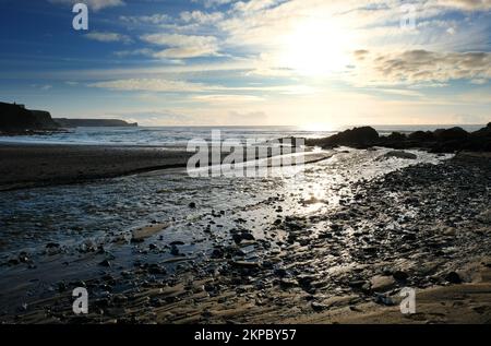 Setting sun over the ocean at Gunwalloe, Cornwall, UK - John Gollop Stock Photo
