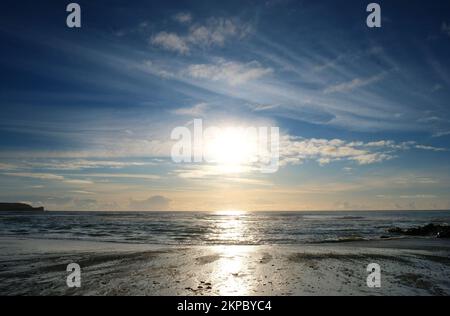 Setting sun over the ocean at Gunwalloe, Cornwall, UK - John Gollop Stock Photo