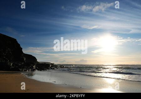 Setting sun over the ocean at Gunwalloe, Cornwall, UK - John Gollop Stock Photo
