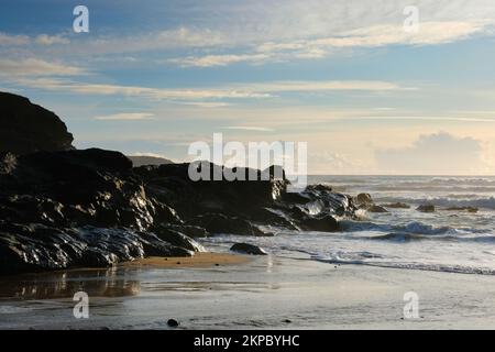 Setting sun over the ocean at Gunwalloe, Cornwall, UK - John Gollop Stock Photo