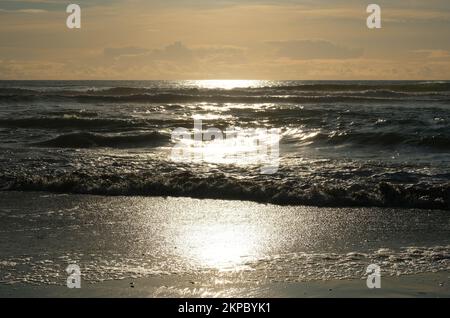 Setting sun over the ocean at Gunwalloe, Cornwall, UK - John Gollop Stock Photo