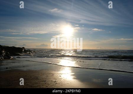 Setting sun over the ocean at Gunwalloe, Cornwall, UK - John Gollop Stock Photo