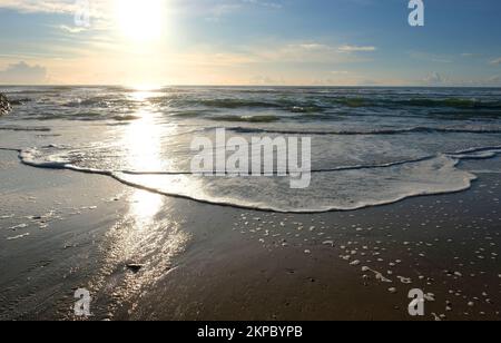 Setting sun over the ocean at Gunwalloe, Cornwall, UK - John Gollop Stock Photo