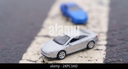 Incidents. Two cars are moving along a solid road marking line. One of the cars is out of focus. Stock Photo