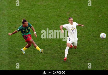 Cameroon's Pierre Kunde and Serbia’s Nemanja Maksimovic (right) during the FIFA World Cup Group G match at the Al Janoub Stadium in Al Wakrah, Qatar. Picture date: Monday November 28, 2022. Stock Photo