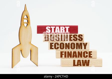 Business and finance concept. On the white surface there is a wooden rocket and planks, on the red plaque the inscription - START Stock Photo