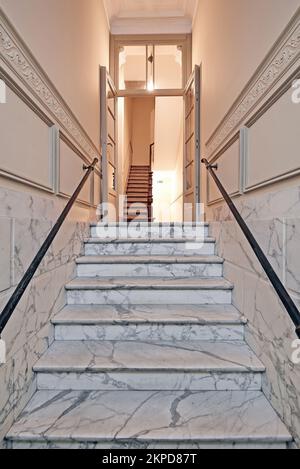 White Marble stairs in renovated mansion stairwell. Vertical and Light on Stock Photo