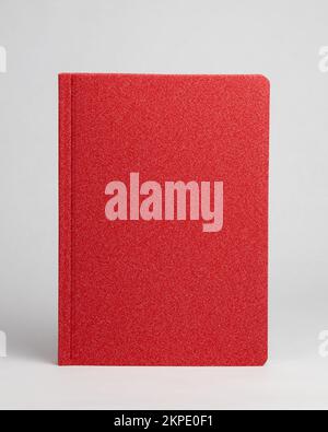 Red diary in standing view on table on white background. Frontside Stock Photo