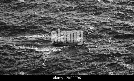 Cargo ship at sea. transit ship. Sailboats. Fishing boat. Fishing. Sightseeing Boat. Boat, ship floating in blue waters. Sunburns and ship reflecting Stock Photo