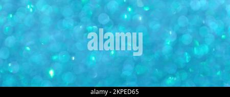 Blurred blue background with circle sparkling lights. Shiny brilliant glittery bokeh of christmas garland. Dark turquoise backdrop Stock Photo