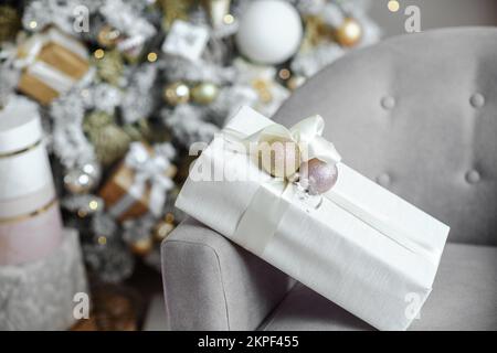 Christmas presents under the Christmas tree. New Year's and Christmas. Wrapped Gift. Beautiful packaging. Ribbon and bow on the packaging. Stock Photo