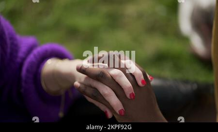Ethnically diverse couple holding hands close-up. Mixed race woman and black man showing love and affection Stock Photo