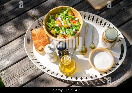 Delicious healthy breakfast served on wooden table in garden Stock Photo