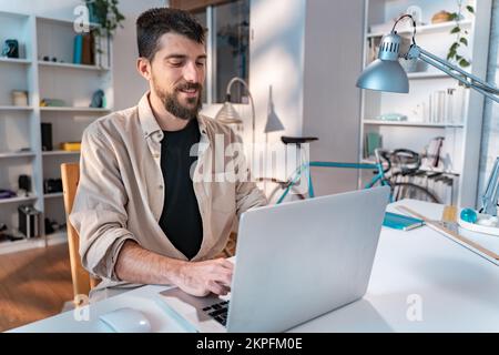 Happy young caucasian freelancer working on laptop at home - Entrepreneur man working remotely  Stock Photo