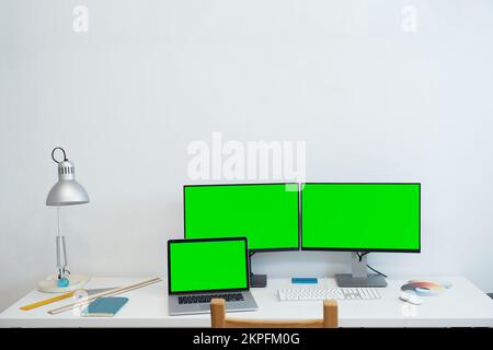 Green screen monitor stands on the office desk - Personal compute mock-up. Stock Photo