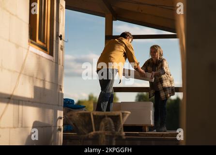 Mature man working on construction site of their new house. Stock Photo
