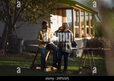 Mature couple having coffee break when working together on construction site of their new house. Stock Photo