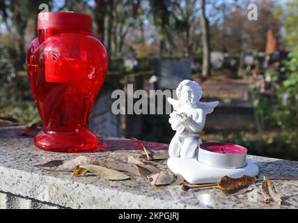 Lantern and an agel figurine on the tombstone in the public cemetery Stock Photo