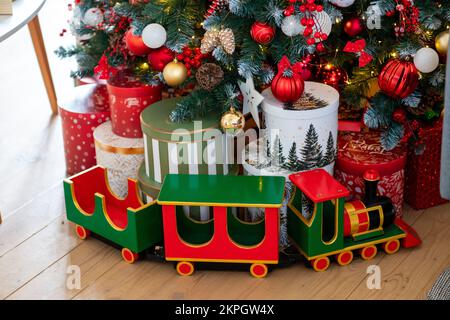 Christmas presents under the Christmas tree. New Year's and Christmas. Wrapped Gift. Beautiful packaging. Ribbon and bow on the packaging. Stock Photo