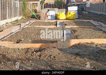 Pumped ready mixed concrete delivered by hose from road direct into trench fill substructure foundation footings of detached house Essex England UK Stock Photo