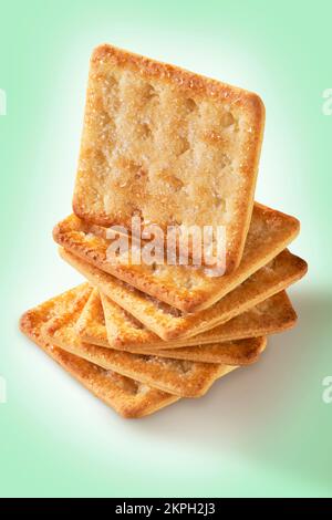 a pile of seven sugar-coated sweet crackers with one standing on top and a greenish background Stock Photo